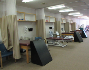 A row of hospital beds and curtains to divide each space and provide privacy