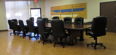 A long board meeting table with chairs in place
