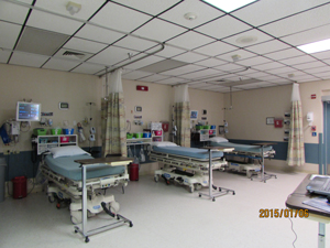 A room with hospital beds, monitors and curtains to provide privacy